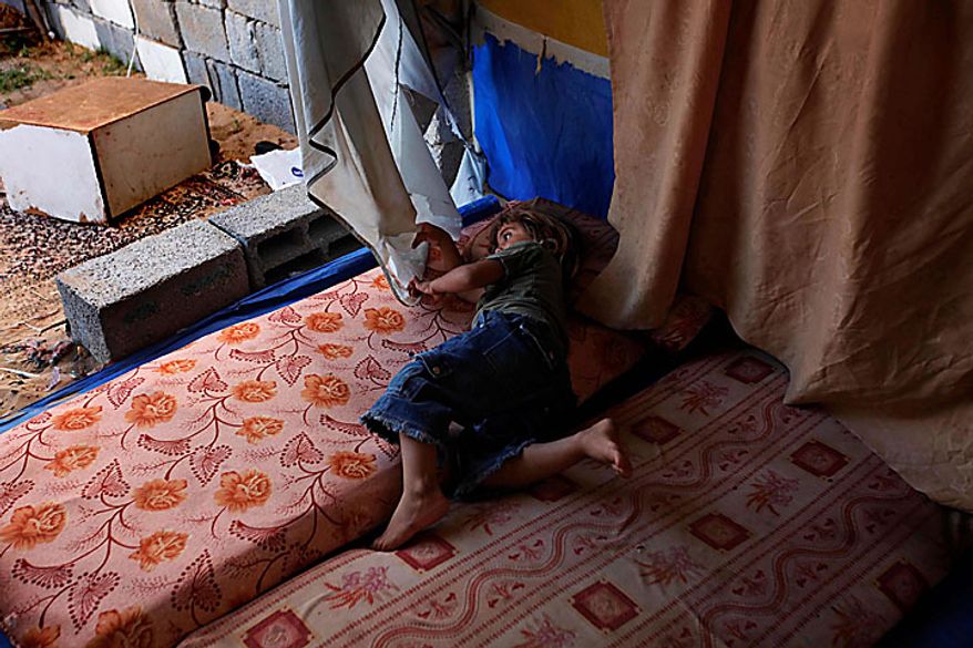 Palestinian Dia Awaja, 4, plays in a tent, part of the makeshift structures that house the family in Beit Lahiya, northern Gaza Strip, Thursday, June 10, 2010. The Awajas are among thousands of families whose houses were destroyed during Israel's three-week military offensive against Hamas-ruled Gaza, launched in December 2008 with the aim of halting Hamas rocket attacks. An Israeli forces bulldozer flattened the Awajas' house and as the family tried to flee, bullets hit father Kamal, his wife Wafa, and their 8-year-old son Ibrahim, who bled to death in the street. (AP Photo/Lefteris Pitarakis)