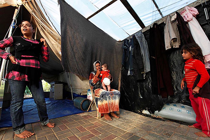 Members of the Awaja family, from left: Omsyat, 13, mother Wafa, 34, five month-old Leyali, and Hala, 8, are seen in a makeshift structure that houses them in Beit Lahiya, northern Gaza Strip, June 10, 2010. The Awajas are among thousands of families whose houses were destroyed during Israel's three-week military offensive against Hamas-ruled Gaza, launched in December 2008 with the aim of halting Hamas rocket attacks. An Israeli forces bulldozer flattened the Awajas' house and as the family tried to flee, bullets hit father Kamal, Wafa, and their 8-year-old son Ibrahim, who bled to death in the street. (AP Photo/Lefteris Pitarakis)