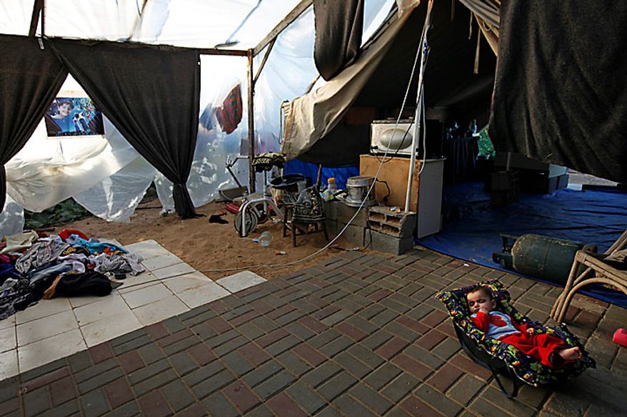 Five month-old Palestinian girl Leyali Awaja sleeps in the makeshift structure that houses her family, in Beit Lahiya, northern Gaza Strip, Thursday June 10, 2010. The Awajas are among thousands of families whose houses were destroyed during Israel's three-week military offensive against Hamas-ruled Gaza, launched in December 2008 with the aim of halting Hamas rocket attacks. An Israeli forces bulldozer flattened the Awajas' house and as the family tried to flee, bullets hit father Kamal, his wife Wafa, and their 8-year-old son Ibrahim, who bled to death in the street. (AP Photo/Lefteris Pitarakis)
