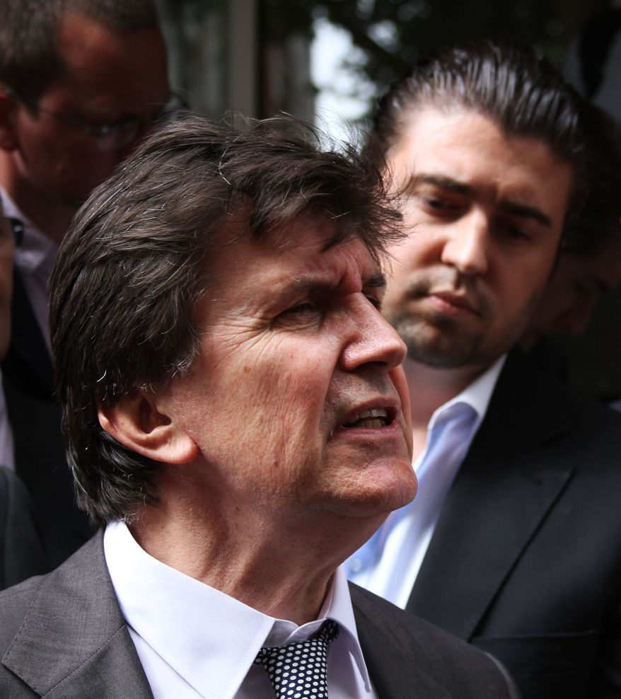 Former Bosnian official Ejup Ganic, with his son, Emir (background), leaves the Westminster Magistrates Court in London on Tuesday, July 27, 2010, after his deportation case for alleged war crime was dismissed. (AP Photo/Roisin Fitzgerald)