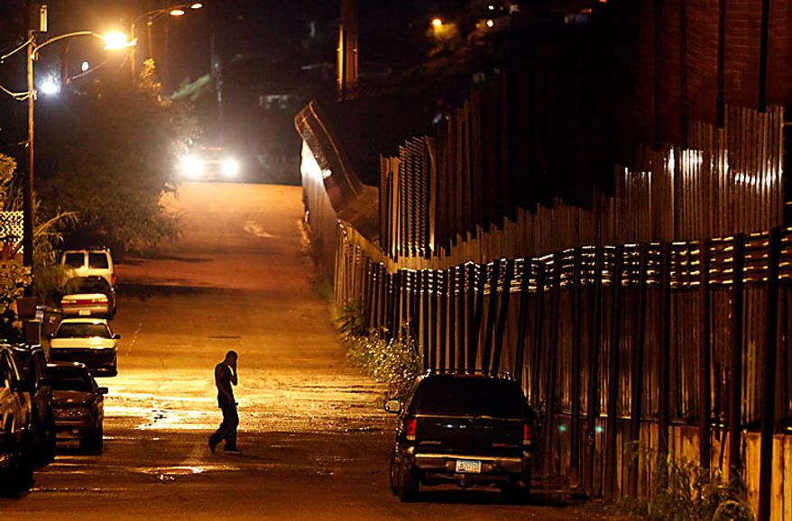 A man talks on the phone as he stands next to the U.S.-Mexico border in Nogales, Ariz., Tuesday, July 27, 2010. Arizona's new immigration law SB1070 takes effect Thursday, July 29. (AP Photo/Jae C. Hong)