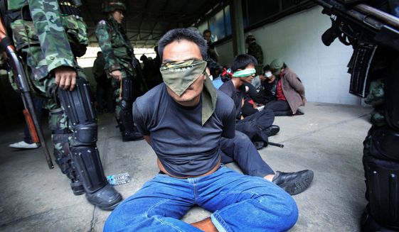 ASSOCIATED PRESS PHOTOGRAPHS
Thai soldiers hold anti-government protesters in their encampment in Bangkok on May 19, ending a nine-month showdown that caused up to 90 deaths.