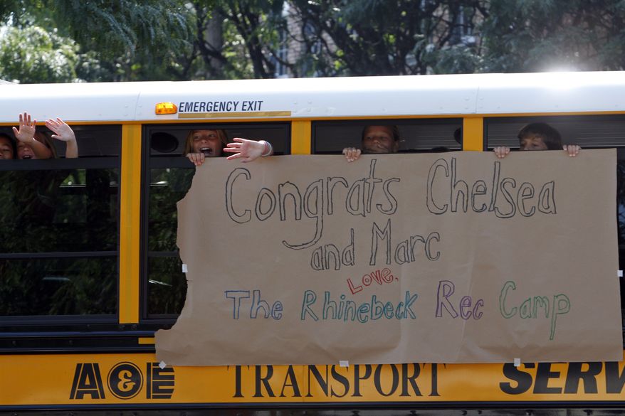 Children wave at members of the media from a bus decorated with a sign congratulating Chelsea Clinton and Marc Mezvinsky on Friday, July 30, 2010 in Rhinebeck, N.Y. (AP Photo/Mary Altaffer)