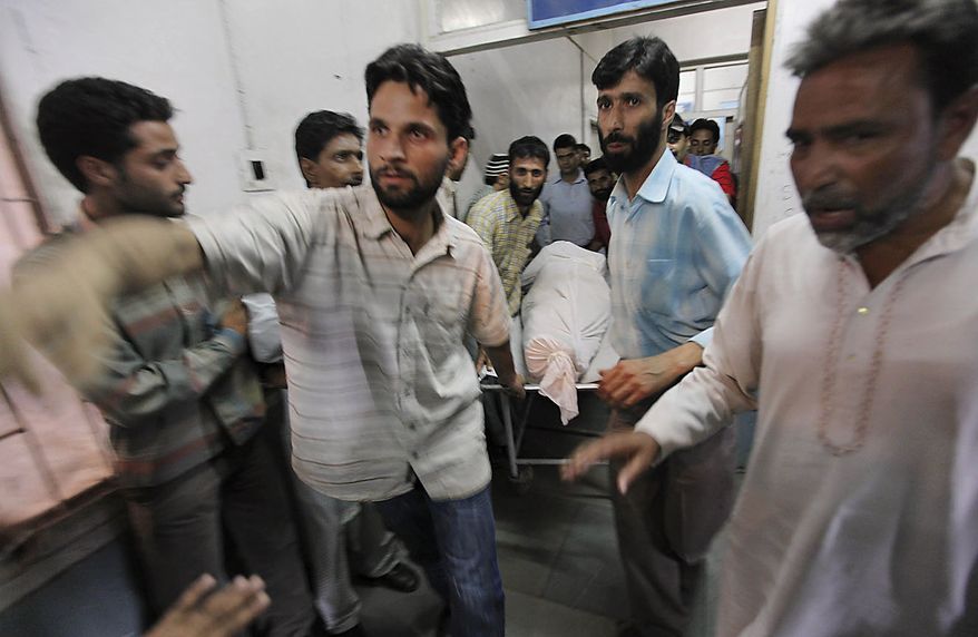 Paramedics carry the body of Showket Ahmad on a stretcher inside a local hospital in Srinagar, India, Friday, July 30, 2010. Paramilitary soldiers fired on hundreds of demonstrators in Indian Kashmir on Friday, killing two men and wounding at least 12 others, police said as protests against Indian rule spread across the region. Showket was one of two civilian killed during a protest in Sopore, some 50 Kilometers (31 miles) northwest of Srinagar. (AP Photo/Dar Yasin)