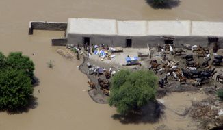 An aerial view shows houses submerged in water because of heavy flooding in Dera Ismail Khan, Pakistan, on Saturday, July 31, 2010. More than 1,100 people have died as rescuers struggle to reach marooned victims and some evacuees show signs of fever, diarrhea and other waterborne diseases. (AP Photo/Ishtiaq Mahsud)