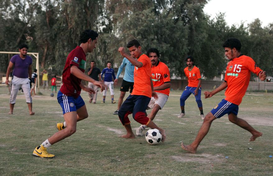 In this photo taken Thursday July 22, 2010, Iraqi men play soccer in central Baghdad, Iraq. As the country is again coming dangerously close to being suspended for the third time from international football, the battle over control of the most popular sport reflects the fault lines of the power struggle over who should lead a new government and even taps into Arab-Kurdish tensions over disputed territory in the north. (AP Photo/ Khalid Mohammed)