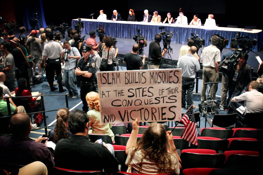 Linda Rivera holds up a sign in opposition to the proposed mosque at 45-47 Park Place during a meeting of the Landmarks Preservation Commission, where the panel voted on the landmark status of the 152-year-old building on Tuesday in New York. The commission voted unanimously not to landmark the building, making way for the construction of the mosque. (Associated Press)