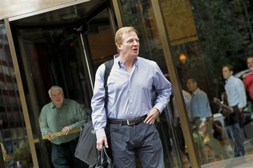 NFL commissioner Roger Goodell, right, and Pro Football Hall of Fame coach John Madden, rear left, leave the NFL offices to board Madden&#x27;s bus the &#x27;Madden Cruiser, &#x27; to visit training camps, Tuesday, Aug. 3, 2010 in New York. (AP Photo/David Goldman)