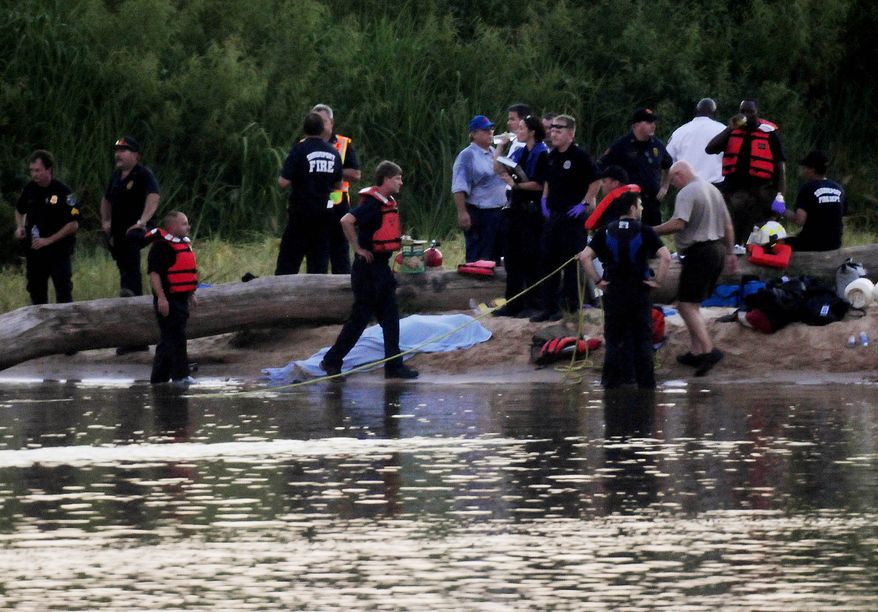 Members of the Shreveport Fire Department and deputies from the Caddo Parish Sheriff's Office work the scene at Charles and Marie Hamel Memorial Park in Shreveport, La., on Monday, Aug. 2, 2010, in search of teens who drowned while swimming in the Red River late Monday afternoon. (AP Photo/Shreveport Times, Henrietta Wildsmith)