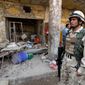 An Iraqi solider stands guard at the scene of an attack in Kut, southeast of Baghdad, on Wednesday. A car bomb ripped through a market in the deadliest of a series of attacks that killed and injured scores on Tuesday, officials said. (Associated Press)
