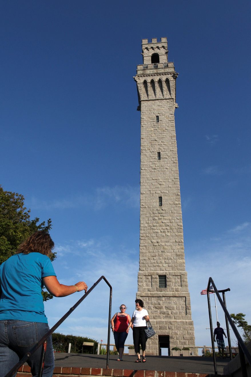 Visitors walk near the Pilgrim Monument in Provincetown, Mass., on the tip of Cape Cod. The tower will mark the 100th anniversary of its dedication on Thursday. (Associated Press)