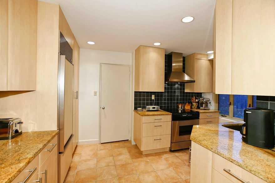 The renovated kitchen has ceramic tile flooring, upgraded cabinets, a floor-to-ceiling pantry, granite counters and stainless steel appliances.