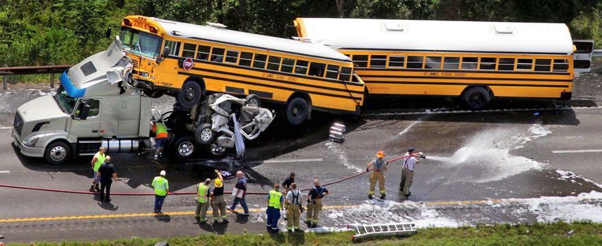 Associated Press
Emergency workers respond to an accident involving two school buses, a tractor trailer and a pickup truck Thursday on I-44 near Gray Summit, Mo. The school buses, carrying high school students, couldn't avoid a wreck of the trucks that had occurred in front of them.