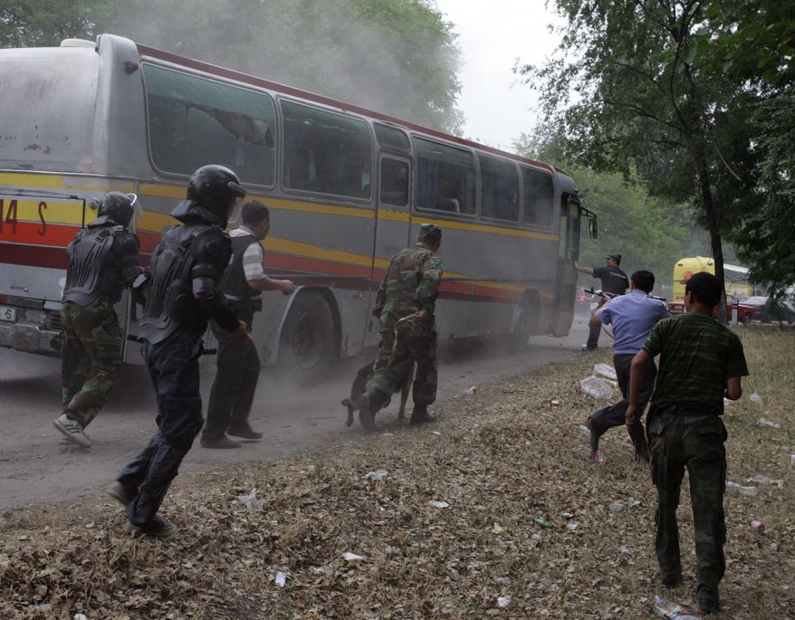 Kyrgyz government forces stop a bus with supporters of former presidential hopeful Urmat Baryktabasov who gathered on a highway some 9 miles east of the capital, Bishkek, on Thursday, Aug. 5, 2010, to demand the resignation of the government. The government forces used tear gas and stun grenades to disperse hundreds of protesters, raising fears of new instability in the turbulent Central Asian nation. (AP Photo)