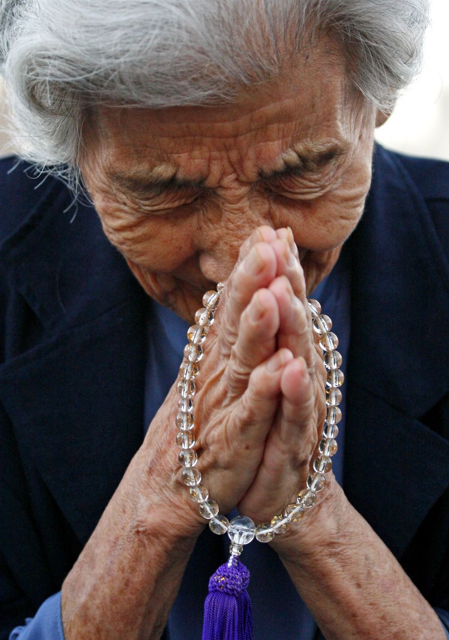 Tsuyuko Nakao, 92, prays for the victims of the Hiroshima atomic bomb attack in front of the cenotaph at the Peace Memorial Park at Hiroshima, western Japan, Friday, Aug. 6, 2010. Hiroshima marked the 65th anniversary of the the world's first atomic bomb attack that devastated the western Japanese city at the closing days of World War II. (AP Photo/Shuji Kajiyama)