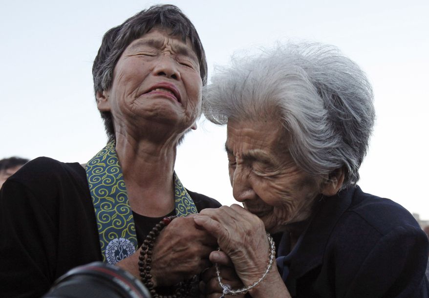Tsuyuko Nakao, 92, right, and Kinuyo Ikegami, 77, both bereaved family members of the atomic bomb victims, console each other as they pray for the victims in front of the cenotaph at the Peace Memorial Park in Hiroshima, western Japan, Friday, Aug. 6, 2010. Hiroshima marked the 65th anniversary of the the world's first atomic bomb attack that devastated the western Japanese city at the closing days of World War II. (AP Photo/Shuji Kajiyama)