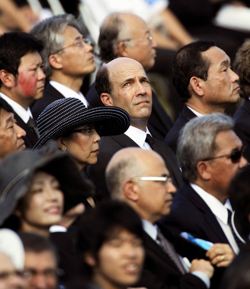 U.S. Ambassador to Japan John Roos, looking upward, takes part in the 65th anniversary of the world's first atomic bombing in the Hiroshima Peace Memorial Park in Hiroshima, western Japan, Friday, Aug. 6, 2010. The United States sent its first ever delegation to the ceremony marking the anniversary of the attacks. (AP Photo/Kyodo News, Shigeyuki Inakuma)