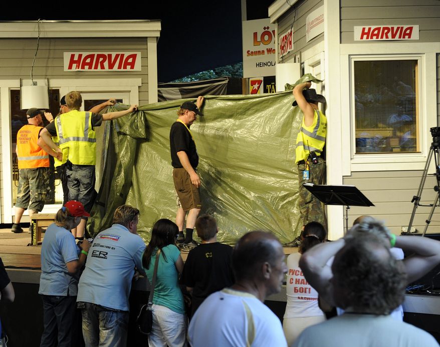 The sauna and the final two competitors, Finland's Timo Kaukonen and Russia's Vladimir Ladyzhenskiy, are shielded by a tarpaulin at the finals of the World Sauna Championships in Heinola, Finland, on Saturday, Aug. 7, 2010. Organizers said Mr. Ladyzhenskiy collapsed and died, while his Finnish rival was rushed to a hospital. (AP Photo/LEHTIKUVA/Sari Gustafsson)