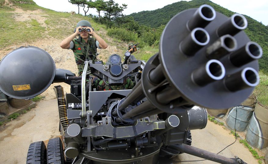 A South Korean marine surveys the situation behind a vulcan automatic cannon during an exercise on Baengnyeong Island, northwest of Seoul near the border with North Korea, on Sunday, Aug. 8, 2010. South Korean troops fired artillery and dropped sonar buoys into the Yellow Sea as naval drills kicked off near the spot where a warship sank four months ago. (AP Photo/Yonhap, Seo Myung-gon)