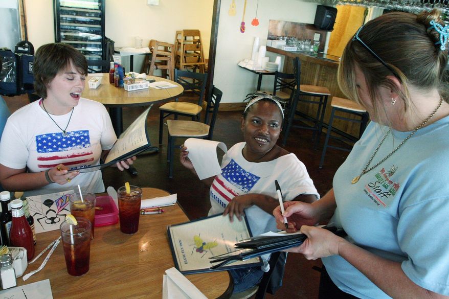STEPHEN DINAN/THE WASHINGTON TIMES
A waitress at Blow-Fly Inn in Gulfport, Miss., takes orders from two members of the "Spending Caravan." The group is traveling along the coast from Bay St. Louis, Miss., to Panama City, Fla., with the sole purpose of spending money to garner attention for the region's businesses.
