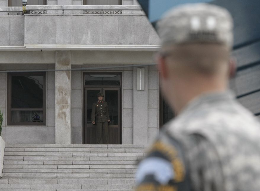 A North Korean soldier, left, looks at the southern side as an U.S. Army soldier looks on at the border village of Panmunjom, South Korea, on Wednesday, Aug. 11, 2010. Relations between the two Koreas have been tense since the deadly sinking of a South Korean warship in late March that Seoul and the United States blame on North Korea. (AP Photo/Ahn Young-joon)