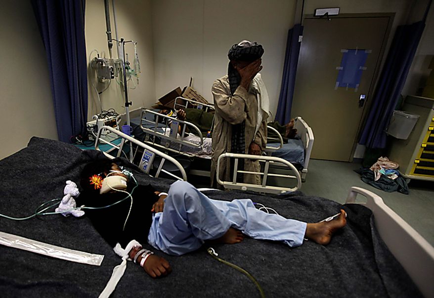 An Afghan man reacts at the bedside of his grand-daughter Rubina, a severely-wounded young Afghan IED victim, at Kandahar Regional Military Hospital, KRMH, inside Camp Hero, Kandahar province, southern Afghanistan, Saturday, Aug. 7, 2010. A U.S Air Force Medical Training Advisory Group, or MTAG team, comprised of 12 medical professionals, is assigned to the Afghan military hospital, and are tasked with providing transitional guidance to local medical workers who treat complicated war victims like Rubina on a daily basis. (AP Photo/Brennan Linsley)
