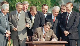 Lawmakers watch closely as Pres. Ronald Reagan signs into law a landmark tax overhaul on the White House South Lawn, Oct. 22, 1986, Washington, D.C. From left, are: Senate Majority Leader Robert Dole of Kansas, Rep. Raymond McGrath, R-N.Y.; Rep. Dan Rostenkowski, D-Ill., Rep. Frank Guerini, D-N.J.; Sen. Russell Long, D-La.; Rep. William Coyne, D-Pa., and Rep. John Duncan, R-Tenn. (AP Photo/Bob Daugherty)