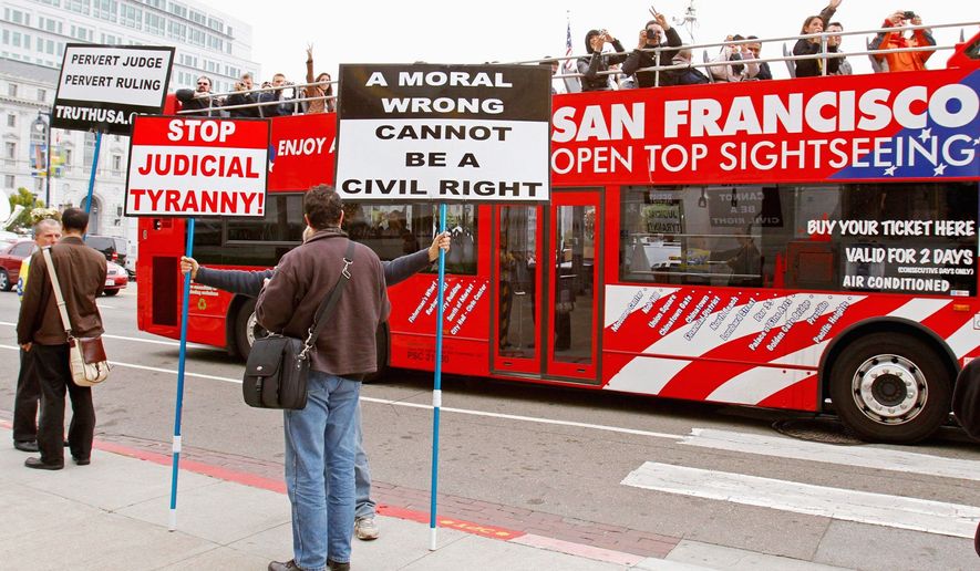 Tourists take photos of gay-marriage foes on Thursday in San Francisco. Federal Judge Vaughn Walker gave opponents of same-sex weddings until Aug. 18 to get an injunction from a three-judge appeals court panel to block his ruling allowing the resumption of gay marriages.