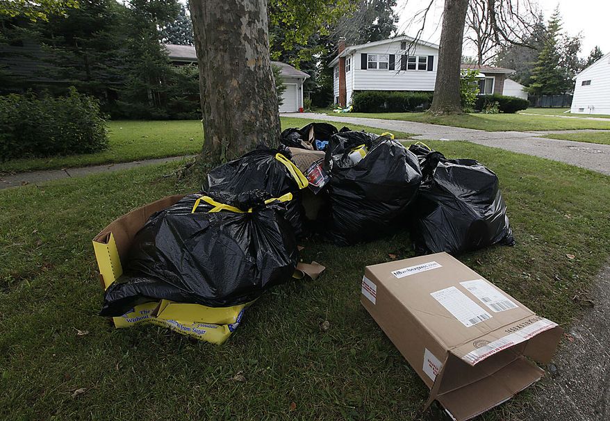 Garbage authorities searched sits outside a home in Flint , Mich., Thursday, Aug. 12, 2010. The box shown was shipped to Elias Ebuelazam. A suspect in a string of 20 stabbings that terrorized people across three states and left five dead was arrested in front of startled passengers at an airport gate in Atlanta as he tried to board a plane for Israel, officials said Thursday. A judge in Flint, Mich., signed a warrant Thursday charging Elias Abuelazam, 33, with assault with intent to murder in connection with a July 27 stabbing. (AP Photo/Paul Sancya)