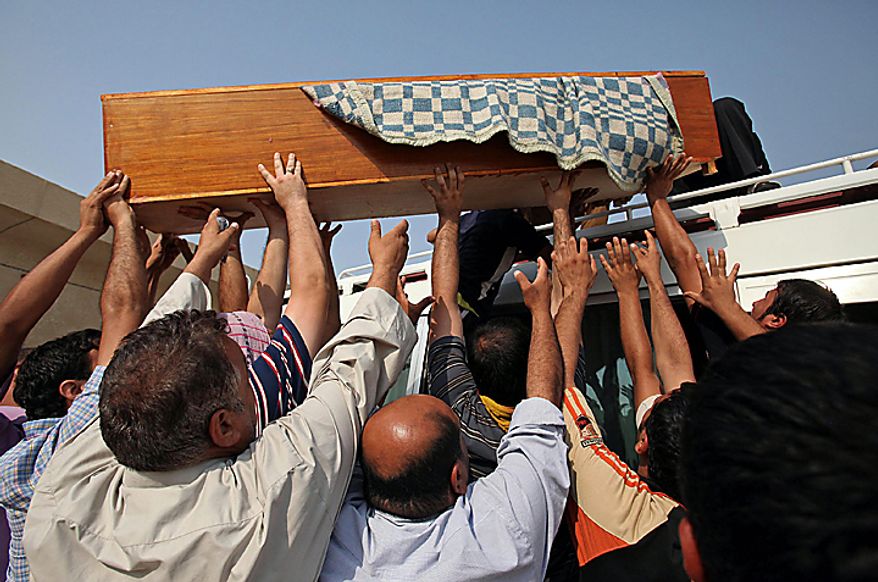 Mourners load the coffin of Sarmd Hamza, 19, onto a vehicle during his funeral in Najaf, south of Baghdad, Iraq, Tuesday, Aug. 17, 2010. Hamza was killed when a suicide bomber sat for hours Tuesday among hundreds of army recruits before detonating nail-packed explosives strapped to his body, killing and wounding dozens of them and casting new doubt on the ability of Iraqi forces as U.S. troops head home. (AP Photo)          