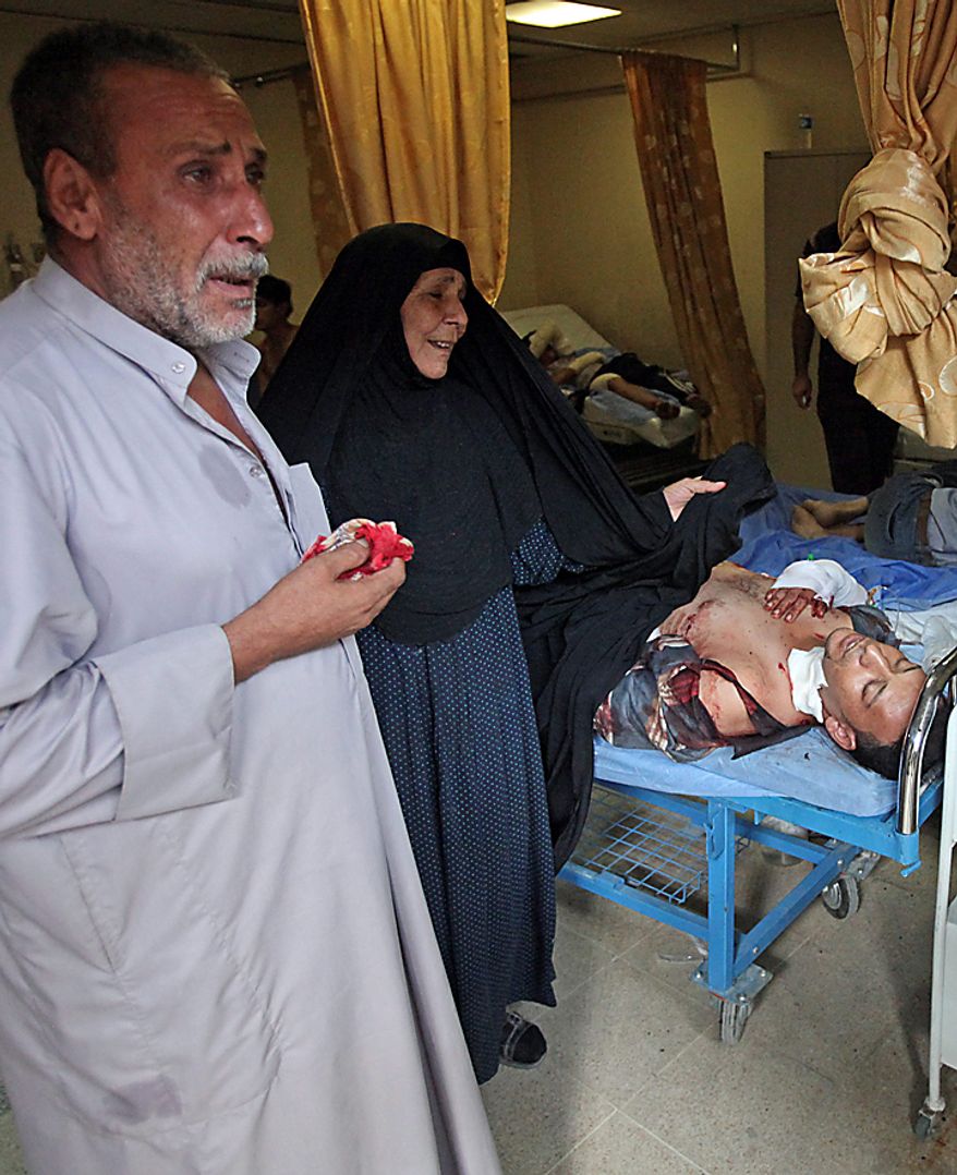 Parents of an injured man react as their son lies in a hospital bed in Baghdad, Iraq, Tuesday, Aug. 17, 2010. A suicide bomber blew himself up Tuesday among dozens of Iraqi army recruits who had gathered near a military headquarters in central Baghdad killing and wounding dozens of them. (AP Photo/Karim Kadim)