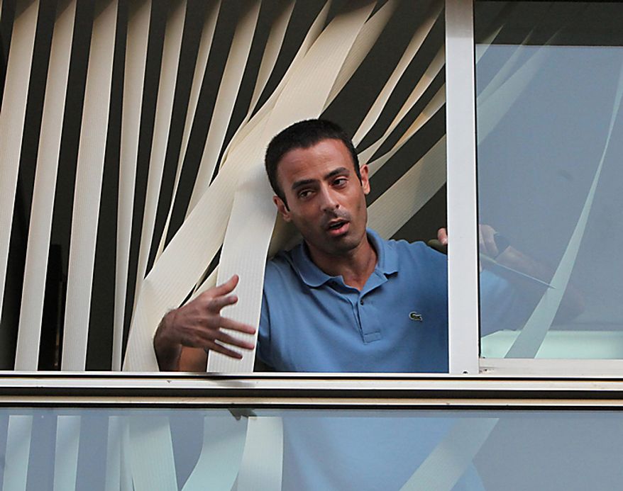A Palestinian man identified by a Turkish news agency as Nadim Injaz stands in the window of the Turkish embassy in Tel Aviv, Israel, Tuesday, Aug. 17, 2010. A Palestinian took hostages in the Turkish Embassy in Tel Aviv Tuesday after shots were fired outside, Israeli police and a Foreign Ministry official said, in an incident that appeared to have only an indirect link to recent tensions between the two countries. (AP Photo/Eli Dassa)