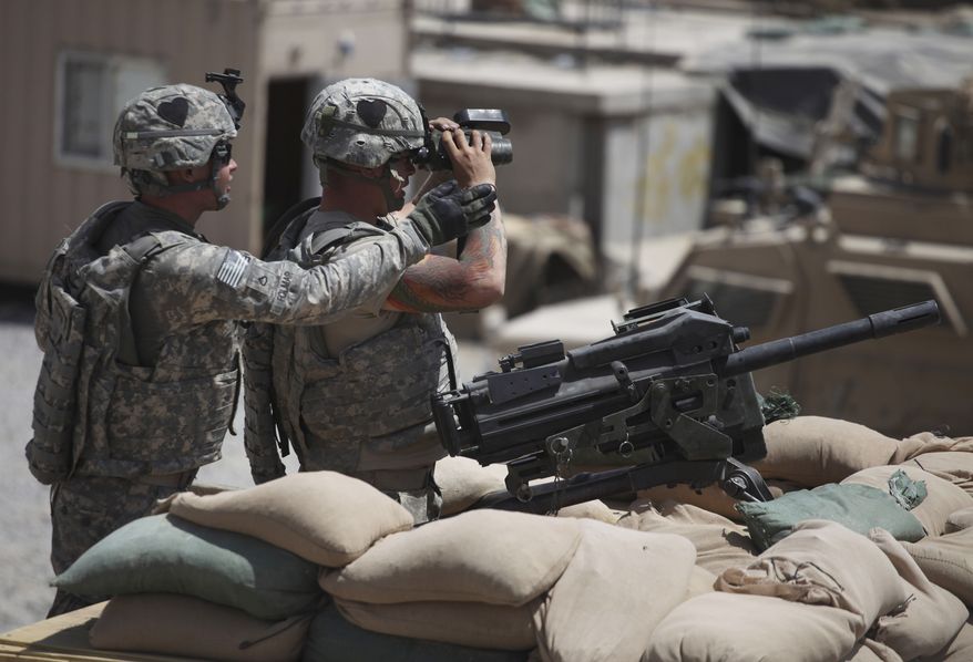 U.S. Army Pfc. Blake Folmar (left), with the 2nd Platoon, Delta Company of the 2nd Battalion, 502nd Infantry Regiment of the 101st Airborne Division, helps a fellow soldier who mans a Mark-19 automatic grenade launcher and uses binoculars to zero in on a nearby Taliban firing position from Forward Operating Base Howz-e-Madad in the Zhari district of Kandahar province in southern Afghanistan on Thursday, Aug. 19, 2010. (AP Photo/Brennan Linsley)