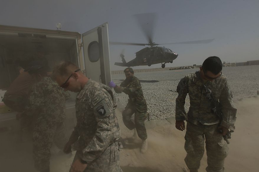 American and Afghan soldiers turn away from the dusty rotor wash as an Afghan soldier and police officer wounded in an ongoing firefight are evacuated by a U.S. Army, 101st Airborne Division, Task Force Destiny medevac helicopter, at the Afghan and U.S. Forward Operating Base Howz-e-Madad, operated by the the 101st's 2nd Battalion, 502nd Infantry Regiment, in Zhari district, Kandahar province, southern Afghanistan, Friday, Aug. 20, 2010. The The 101st Airborne's 2-502 and their Afghan Army partners operate in a district which, as the birthplace of the Taliban movement, continues to hold many well-armed fighters, and a support network which provides the fighters with improvised explosives and safe havens. (AP Photo/Brennan Linsley)