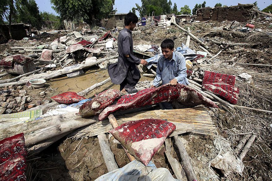 Flood survivors collect their belonging amid of rubble of their houses as water recede in Aza Kheil, Pakistan on Friday, Aug. 20, 2010. Massive flooding in Pakistan appears to be draining support for the already-weak civilian government while boosting the powerful military, a blow to U.S. and domestic hopes for a strong Pakistani democracy capable of undercutting the allure of al-Qaida and the Taliban.(AP Photo/Mohammad Sajjad)