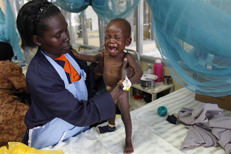 In this Friday, Oct. 30, 2009 picture a caretaker looks after a baby girl in the Siaya hospital in Western Kenya. The girl was found abandoned in the street and suffering with malaria. For Africans wondering whether the malaria drugs they've bought are real, there may soon be a quick way of finding out: sending a text message. Across the continent, more than 30 percent of malaria medicines are estimated to be fake, and many look identical to the real thing. A new project called mPedigree lets consumers send in a code via text message that lets them check if their drugs are genuine. (AP Photo/Karel Prinsloo)