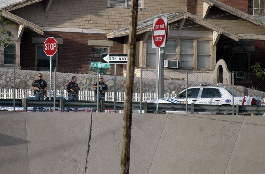 ** FILE ** El Paso police officers lookout into the Mexican border city of Ciudad Juarez after a heavy gun battle erupted in Ciudad Juarez, Mexico, Saturday, Aug. 21, 2010. (AP Photo/Raymundo Ruiz)
