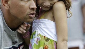 New York Yankees third baseman Alex Rodriguez is shown holding his daughter Natasha on the field during a Yankees HOPE week baseball game after the Yankees regular baseball game against the Detroit Tigers at Yankee Stadium in New York, Thursday, Aug. 19, 2010. (AP Photo/Kathy Willens)