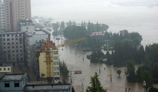 Roads along the Yalu River are inundated by floodwaters in Dandong in northeast China&#x27;s Liaoning province on Saturday, Aug. 21, 2010. The Yalu, which marks China&#x27;s border with North Korea, breached a dike Saturday after torrential rains, forcing the evacuation of more than 94,000 people. (AP Photos/Xinhua News Agency, Zhao Guiliang) 
