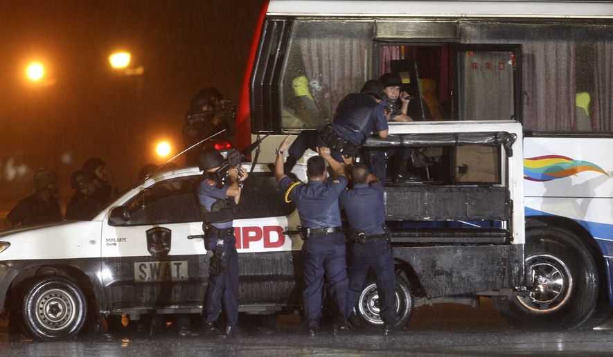 Police and SWAT members assault a tourist bus to rescue hostages at Manila&#x27;s Rizal Park Monday, Aug. 23, 2010. Rolando Mendoza, a dismissed policeman armed with automatic rifle, seized the bus with 25 people aboard, mostly foreign tourists in a bid to demand reinstatement, police said. Mendoza was killed along with an undetermined number of hostages. (AP Photo/Bullit Marquez)