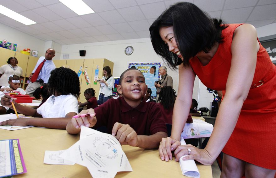 D.C. Public Schools Chancellor Michelle Rhee (right) talks with third-grader Kmone Feeling, who wants to be a librarian, during a visit to J.O. Wilson Elementary School in Northeast Washington on Monday, Aug. 23, 2010, the first day of the new academic year. D.C. Mayor Adrian M. Fenty (second from left) and Principal Sheryl Warley (left) stand at the back. (AP Photo/Manuel Balce Ceneta)