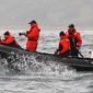 Russian Prime Minister Vladimir Putin aims a crossbow as he is on a rubber boat at the Olga Harbor of Kamchatka Peninsula during a scientific expedition, to study grey whales on Wednesday, Aug.25, 2010. (AP Photo/ RIA Novosti, Alexei Druzhinin, pool)