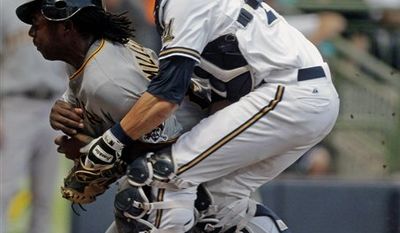 Milwaukee Brewers catcher Jonathan Lucroy, right, cannot hold on to the ball as he collides with Pittsburgh Pirates' Lastings Milledge at home during the second inning of a baseball game Friday, Aug. 27, 2010, in Milwaukee. Milledge scored from second on a hit by Ronny Cedeno. (AP Photo/Morry Gash)