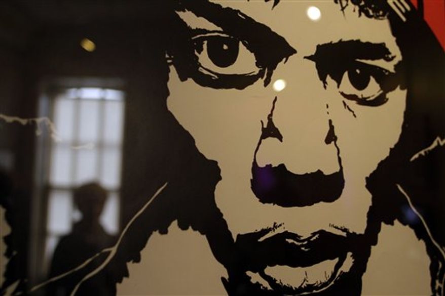 A journalist walks around an exhibition devoted to US musician Jimi Hendrix, being held, at the Handel House Museum in central London, Tuesday Aug. 24, 2010. They were both immigrants in Britain who changed the face of music, one with a harpsichord and a composer's pen, the other with an electric guitar. George Frideric Handel and Jimi Hendrix also shared an address, living 200 years apart in adjoining 18th-century London houses. Now, 40 years after Hendrix's death, a new exhibition about his London years brings these two unlikely neighbors together. Handel lived at 25 Brook Street, a Georgian house in the tony Mayfair area for 36 years until his death in 1759. The museum devoted to his life uses the adjoining upstairs apartment where Hendrix lived as offices. (AP Photo/Lefteris Pitarakis)