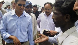 A Pakistani flood survivor interacts with Rajiv Shah, left, administrator of the U.S. Agency for International Development, during his visit to camp in Sukkur, Pakistan on Wednesday, Aug. 25, 2010. (AP Photo/Khurram Shahzad)