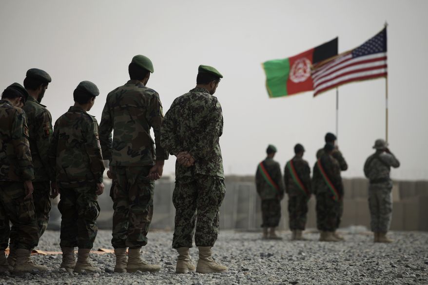 Afghan and American soldiers participate in a memorial service for an Afghan army officer at Forward Operating Base Howz-e-Madad in the Zhari district of Kandahar province in southern Afghanistan on Friday, Aug. 27, 2010. The officer was killed in an insurgent ambush a day earlier. (AP Photo/Brennan Linsley)