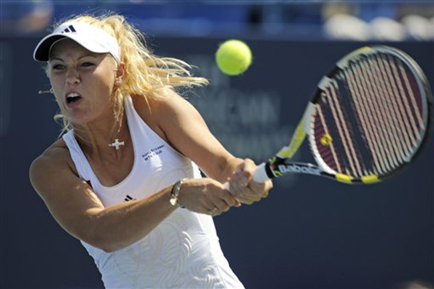 Caroline Wozniacki, of Denmark, lifts her trophy after defeating Nadia Petrova, of Russia, 6-3, 3-6, 6-3, in the women&#39;s final of the Pilot Pen tennis tournament in New Haven, Conn., on Saturday, Aug. 28, 2010. (AP Photo/Fred Beckham)