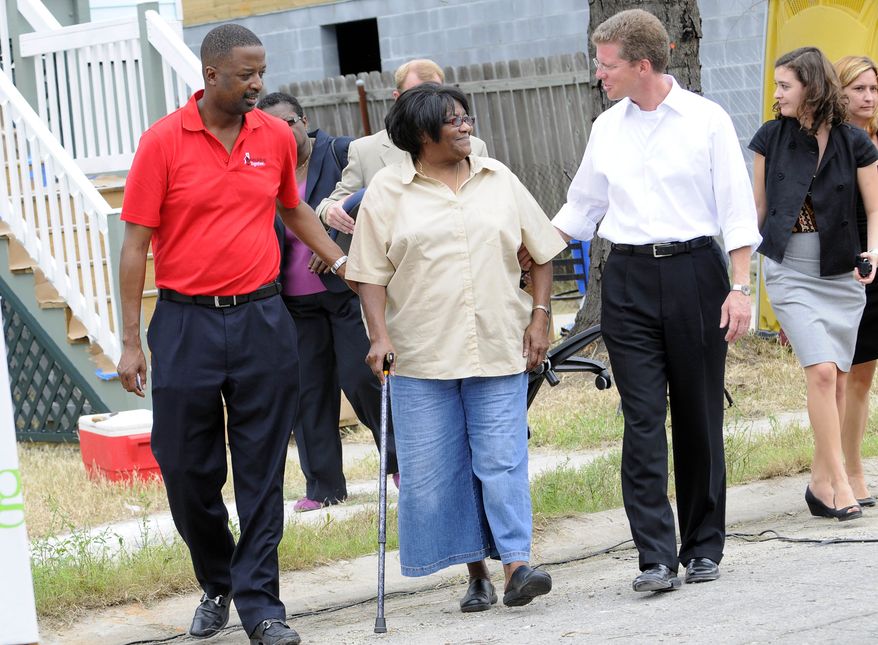 Gary Officer (left), CEO of Rebuilding Together, and Shaun Donovan (right), secretary of housing and urban development, escort homeowner Ruthie Lee Jones, whose home is one of 50 being rebuilt in five days by volunteers from around the country as part of Rebuilding Together's Fifty for Five in the Gentilly neighborhood of New Orleans on Thursday, Aug. 26, 2010. Ms. Jones has not been in her home since Katrina devastated the New Orleans and the Gulf Coast in 2005. (Cheryl Gerber/AP Images for Rebuilding Together)