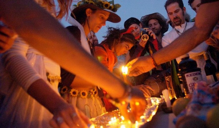 Candles are lit during a service to celebrate Shabbat in Blackrock City during the Burning Man celebration. Focusing on "radical self-reliance," participants must provide their own food, water and trash disposal as they camp in the desert environment, where daily temperatures routinely reach 110 degrees. (The Washington Times)
