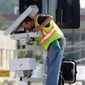 Technician Charles Riggings in March services traffic cameras designed to catch speeders and motorists who run red lights in Los Angeles. (Associated Press)